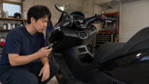 マグザムのような大型スクーターでキー認識やエラー表示を確認する男性